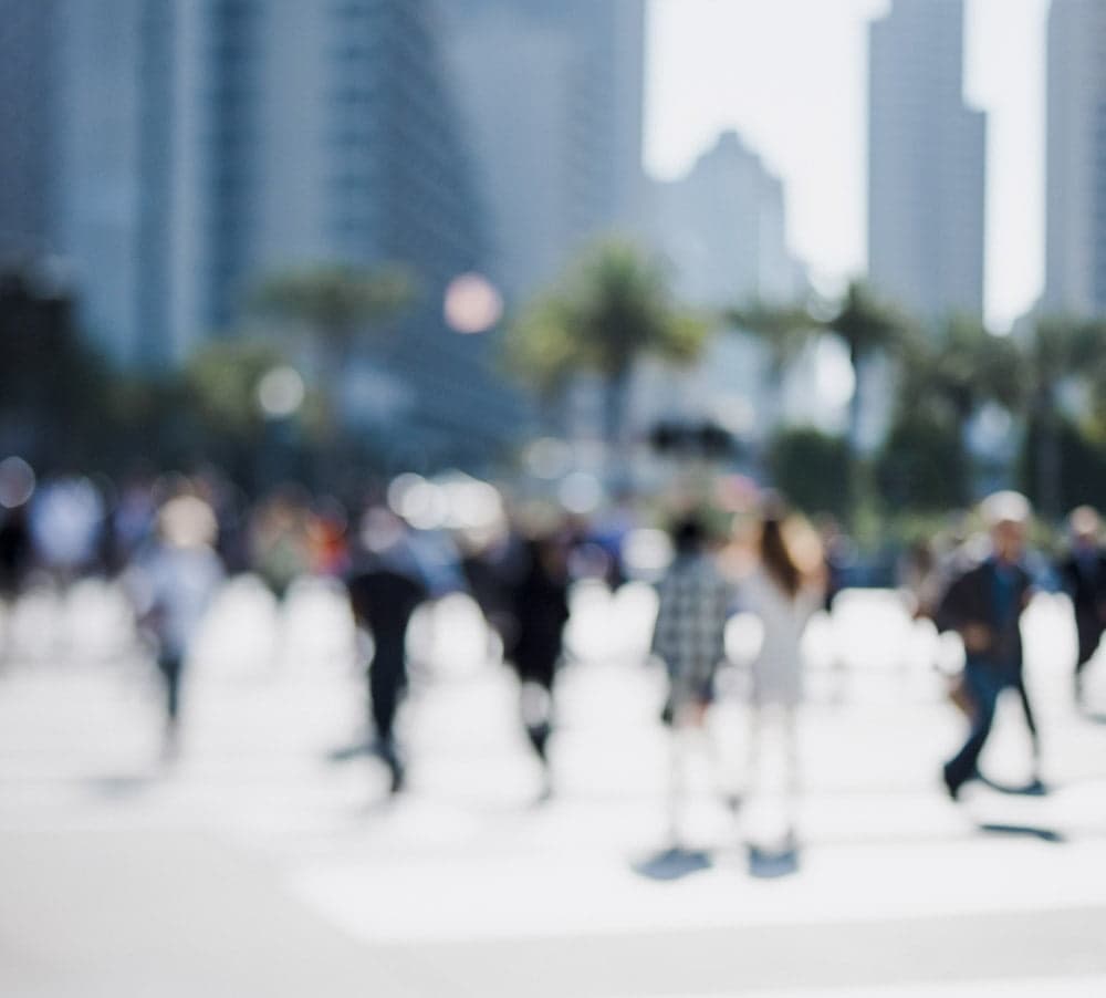 A crowd of people crossing a city street
